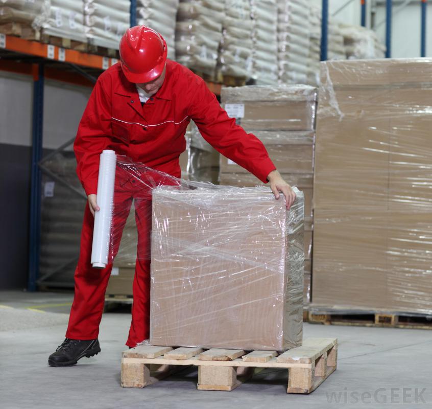 man-in-red-outfit-and-hard-hat-wrapping-plastic-around-boxes.jpg